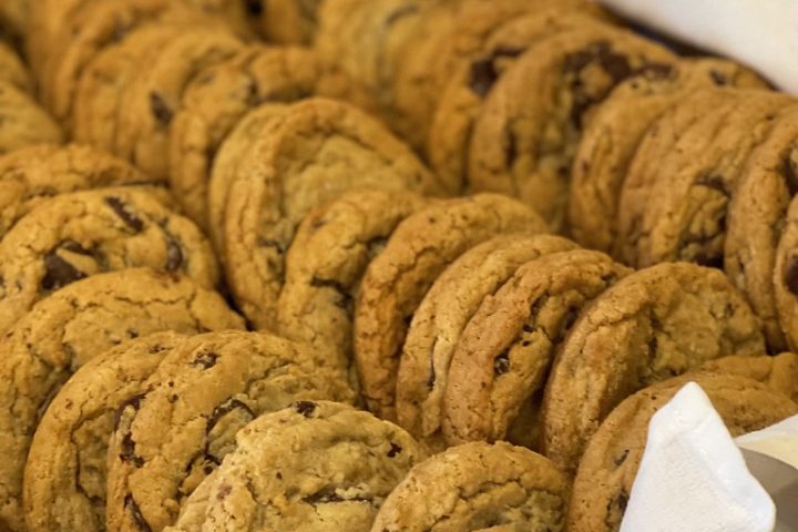 Rows of freshly baked chocolate chip cookies cooling on a tray