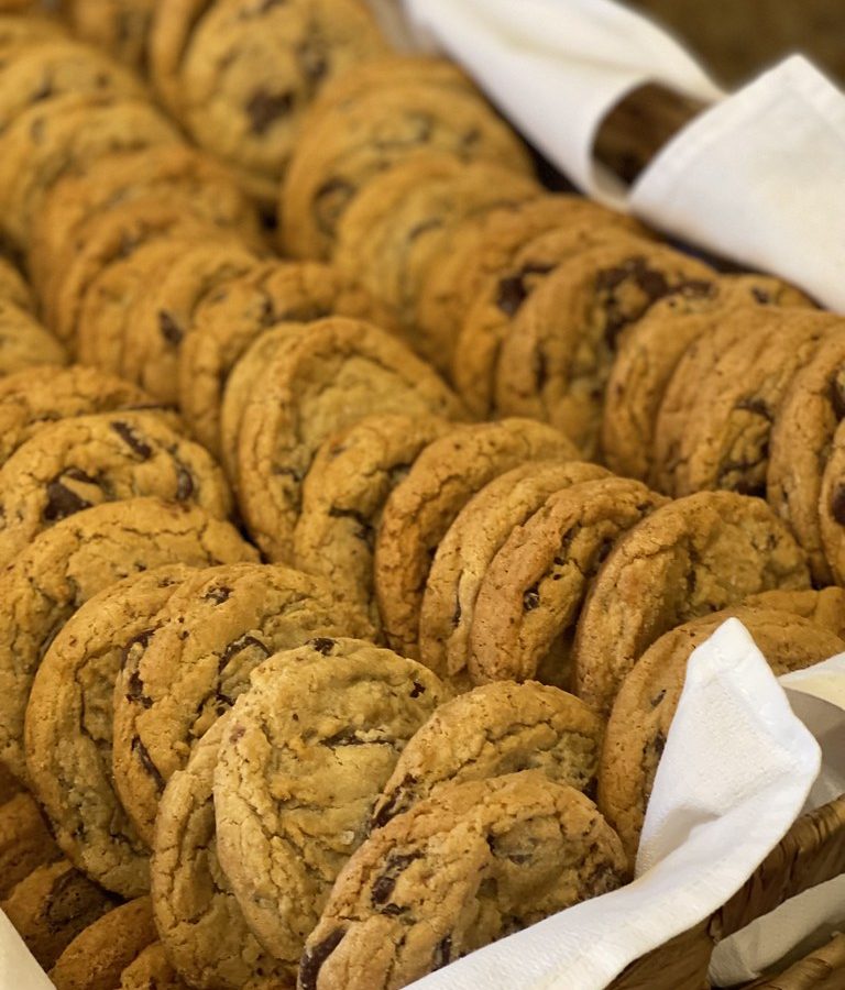 Rows of freshly baked chocolate chip cookies cooling on a tray