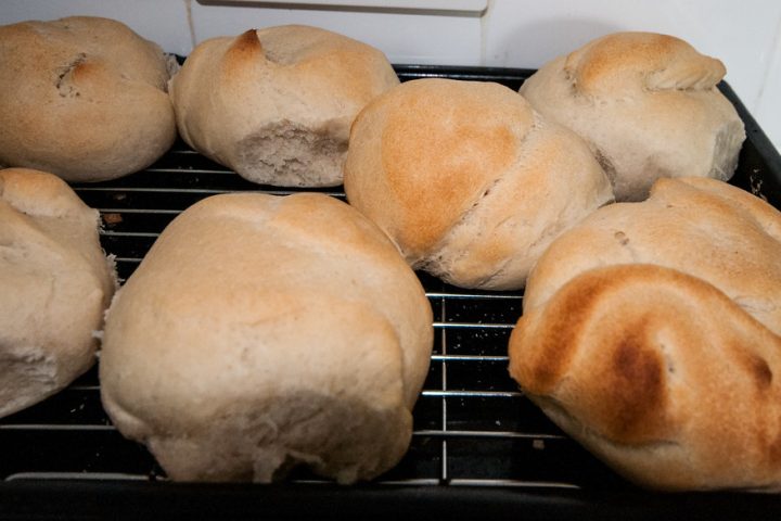 Soft white bread rolls cooling on a wire rack