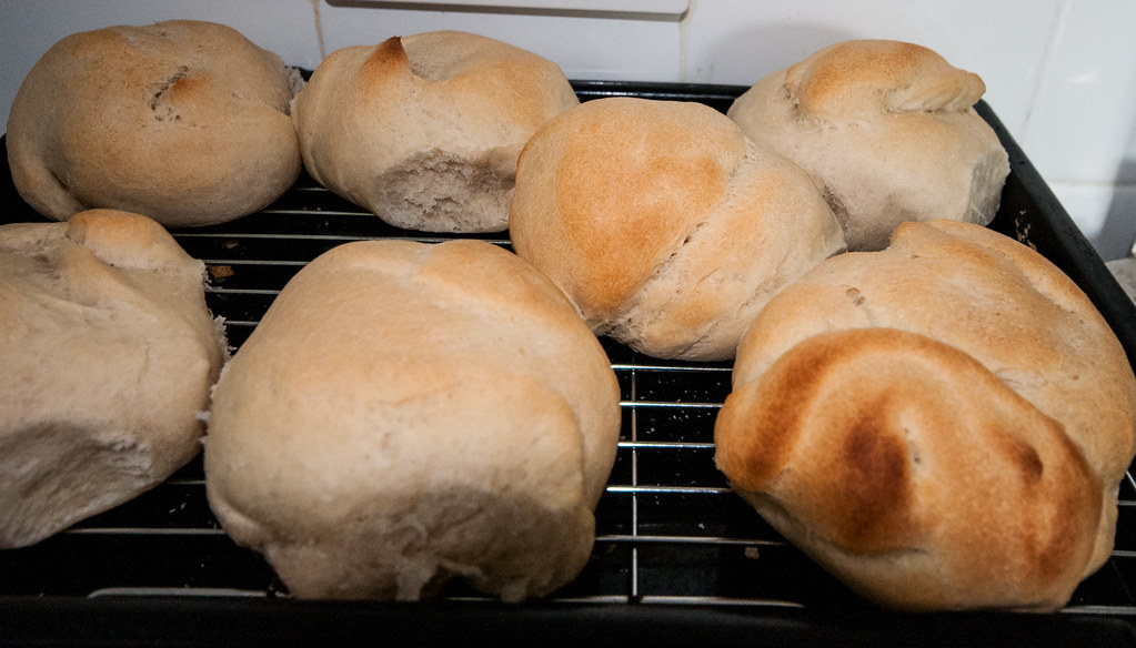 Soft white bread rolls cooling on a wire rack