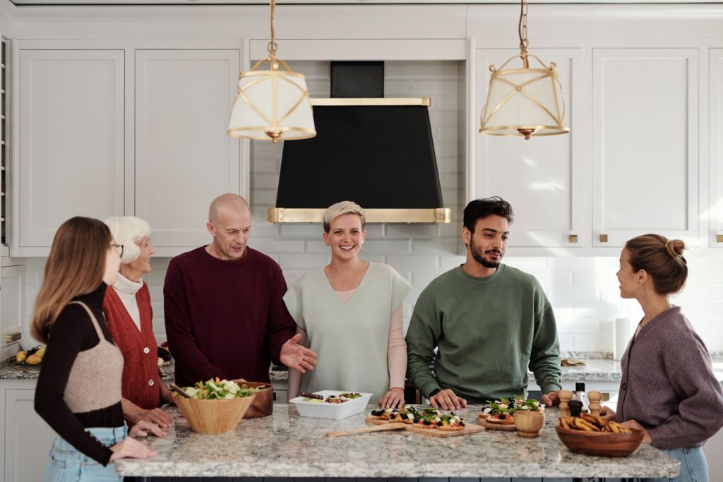 A family gathered around a kitchen island preparing a meal together in a bright modern kitchen