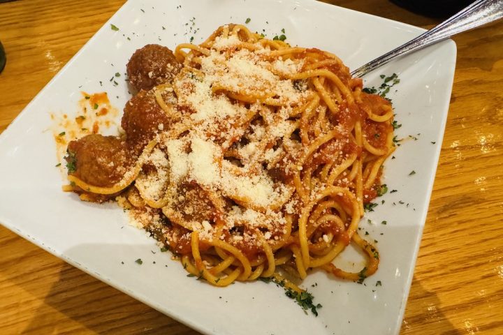 Spaghetti topped with meatballs in tomato sauce and grated cheese