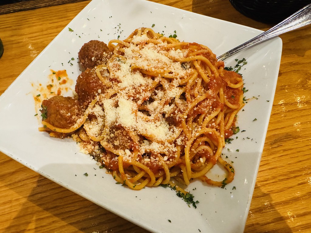 Spaghetti topped with meatballs in tomato sauce and grated cheese