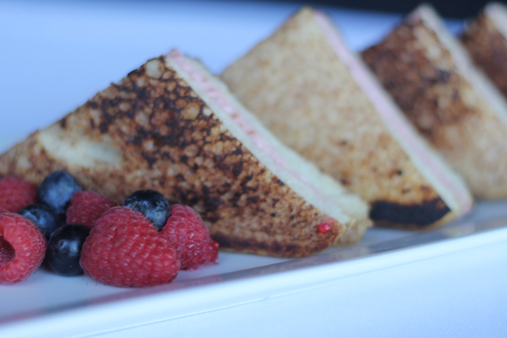 Stuffed French toast cut into triangles and served with fresh raspberries and blueberries