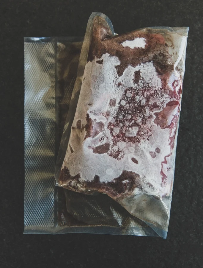 A bag of frozen meat covered in a layer of frost