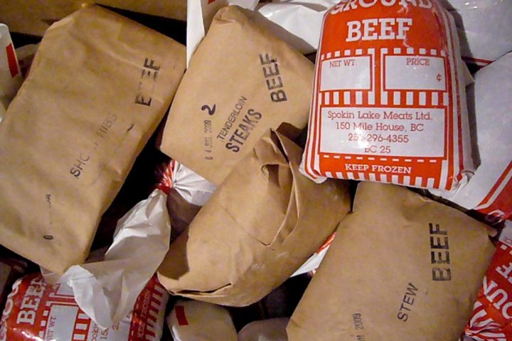 Frozen packages of beef wrapped in brown paper and labelled with their contents