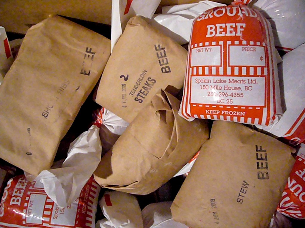 Frozen packages of beef wrapped in brown paper and labelled with their contents