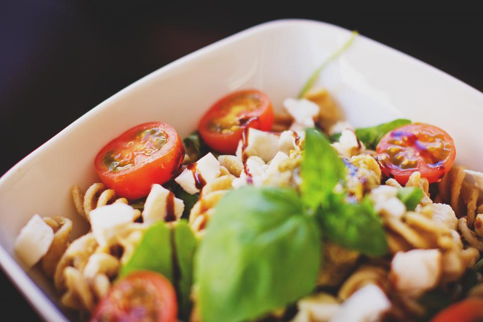 Pasta salad with halved cherry tomatoes, mozzarella and fresh basil