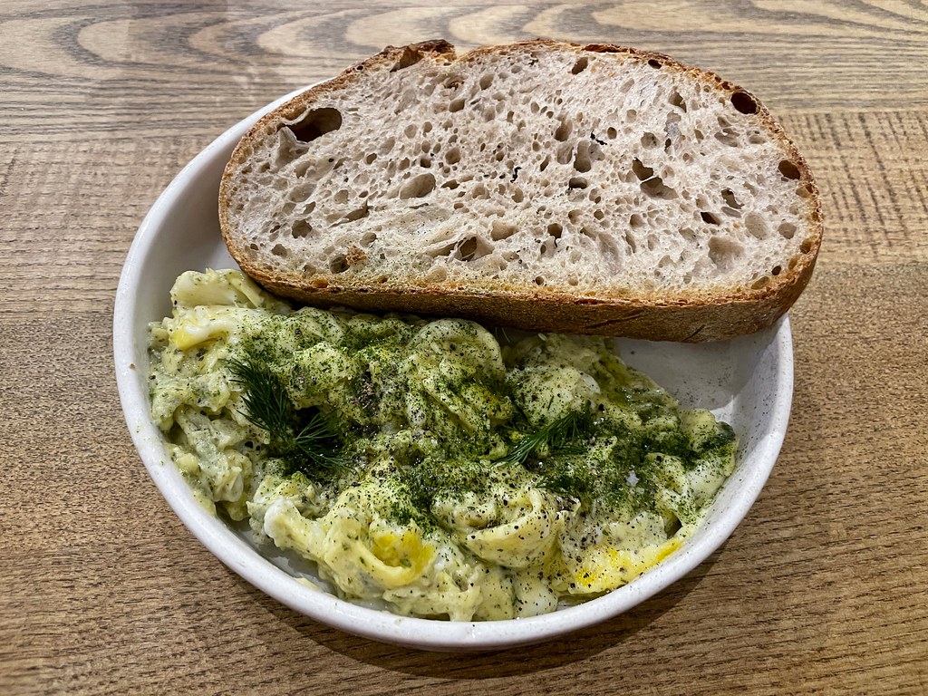 Scrambled eggs scattered with herbs, served with a thick slice of sourdough toast
