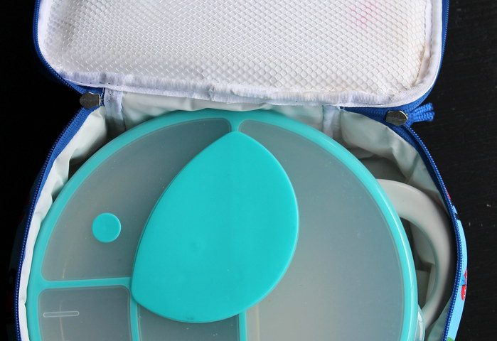 A children's divided snack box inside an open insulated lunch bag