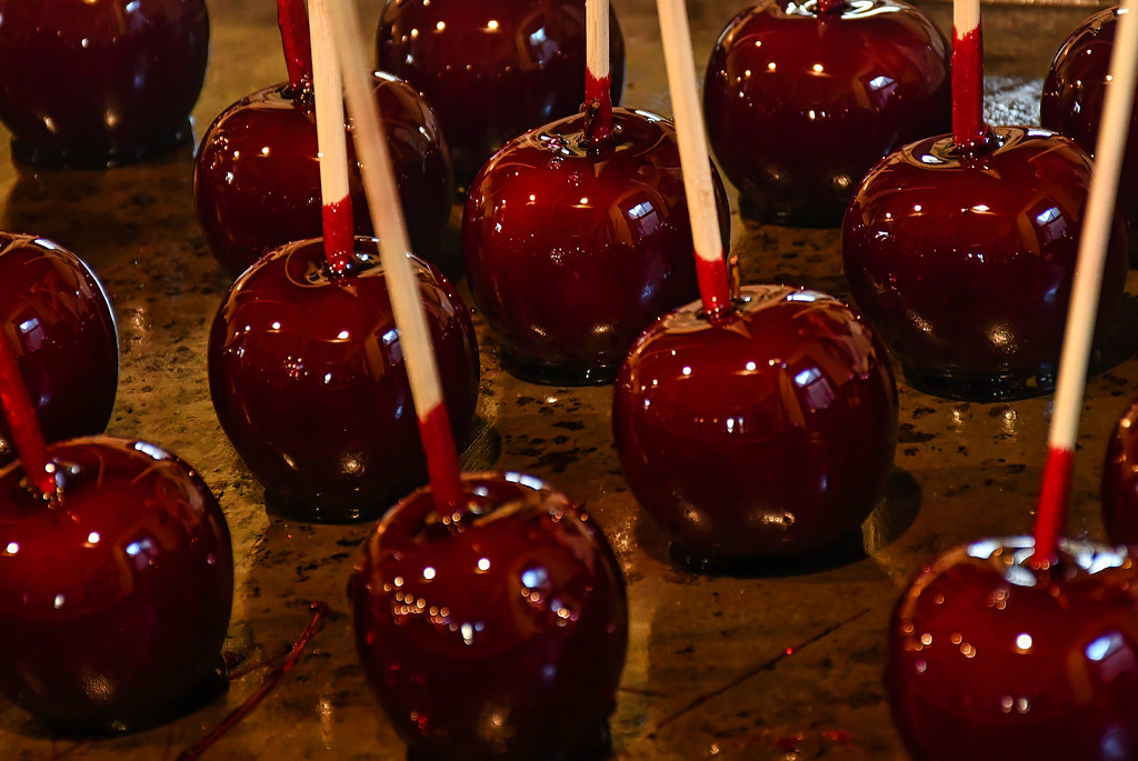 Rows of shiny red toffee apples on wooden sticks